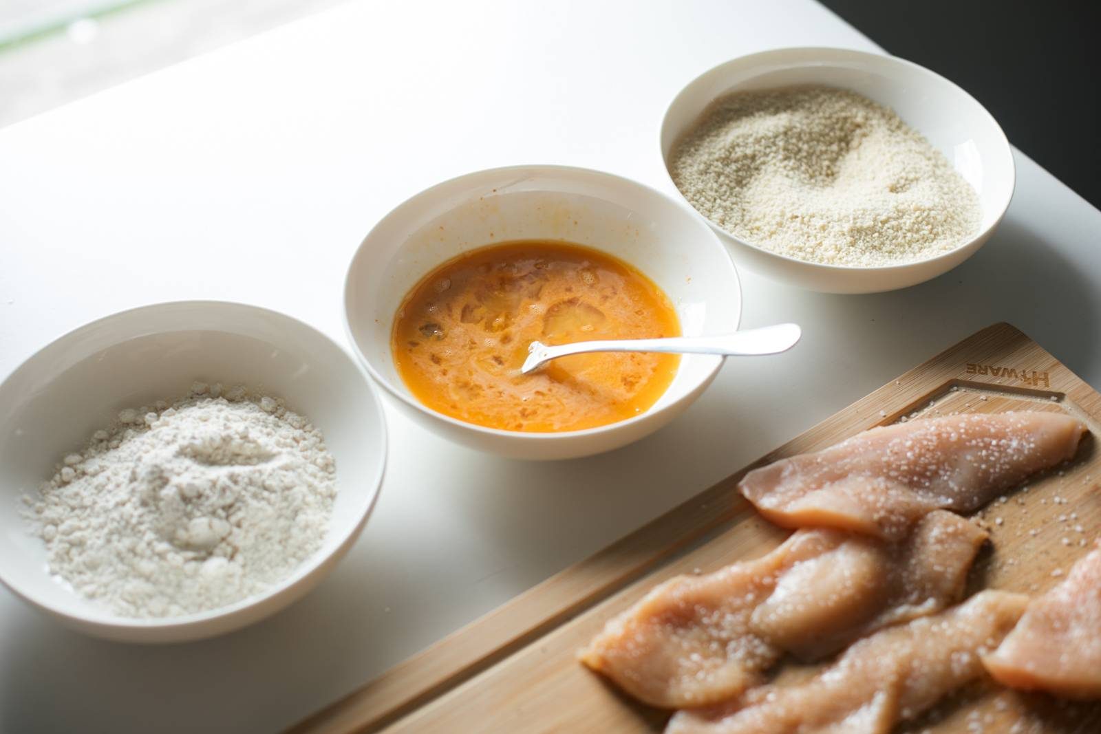 Flour, eggs, and breadcrumbs in bowls for dipping.