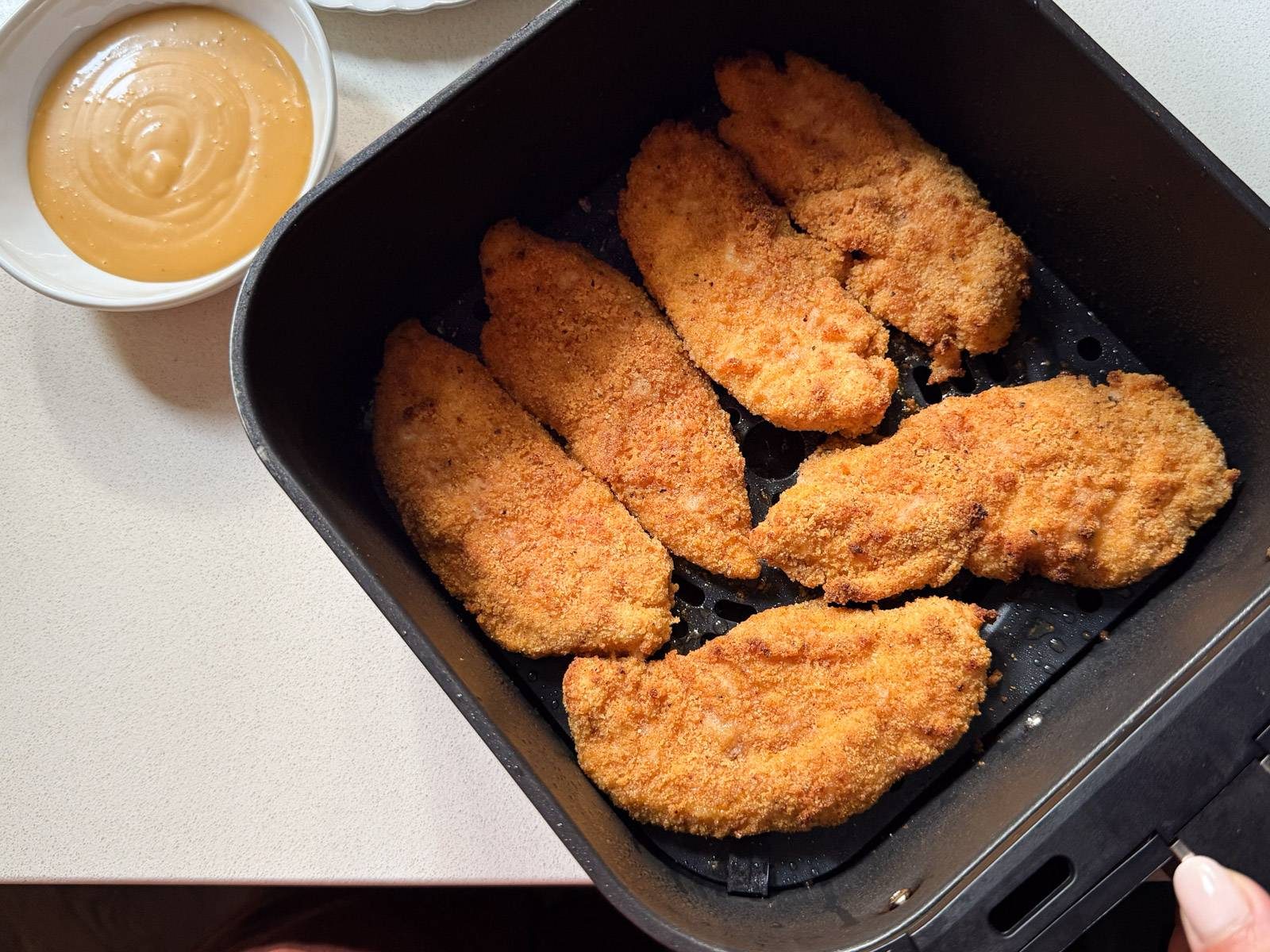 Breaded chicken tenderloins cooked in an air fryer.