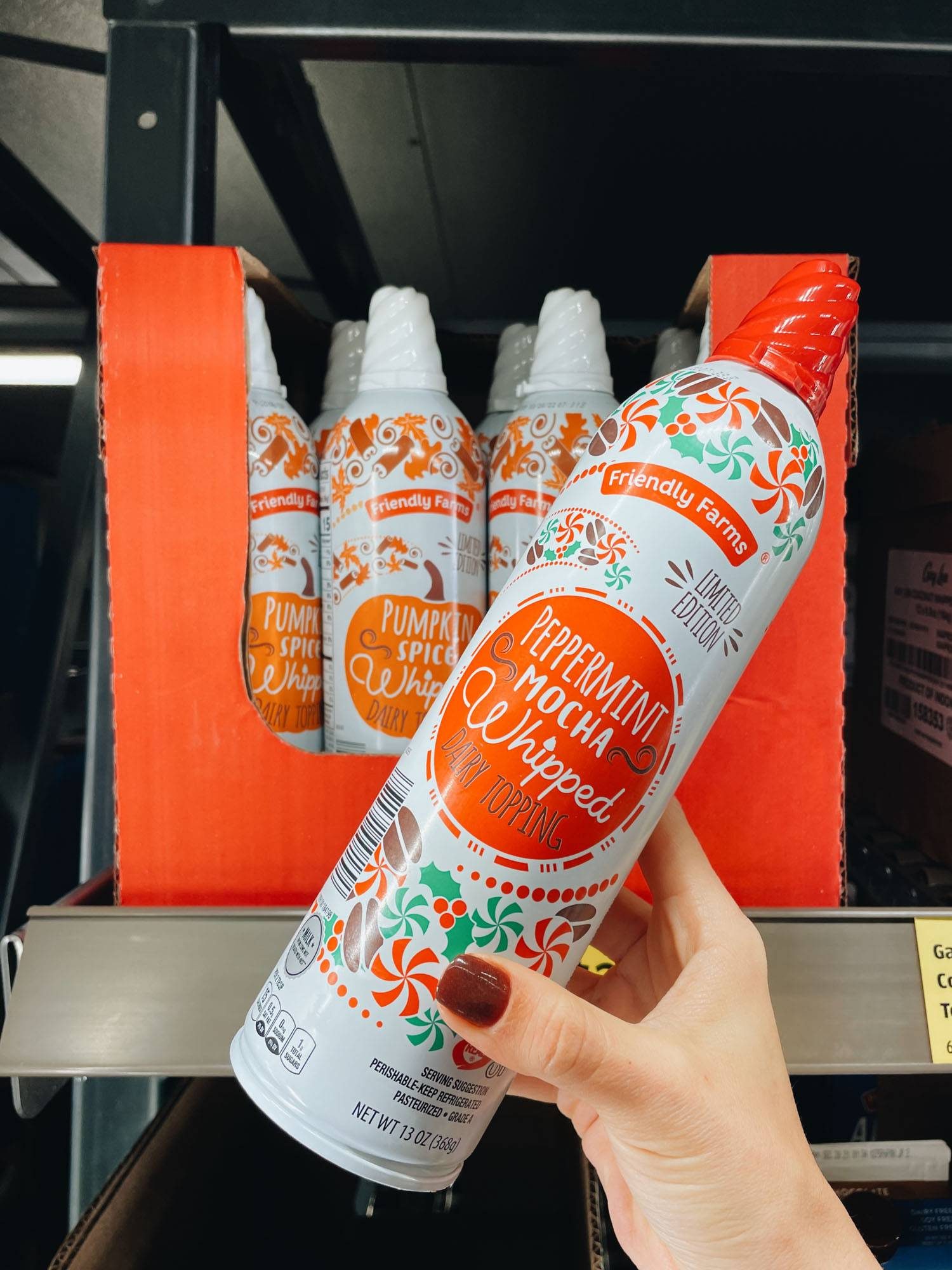 White hand holding peppermint mocha whipped cream