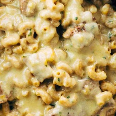 Steak and Cheddar Mac and Cheese in a pot with a spoon.