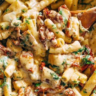 Sun Dried Tomato Chicken Florentine Pasta in a pan with a spoon.