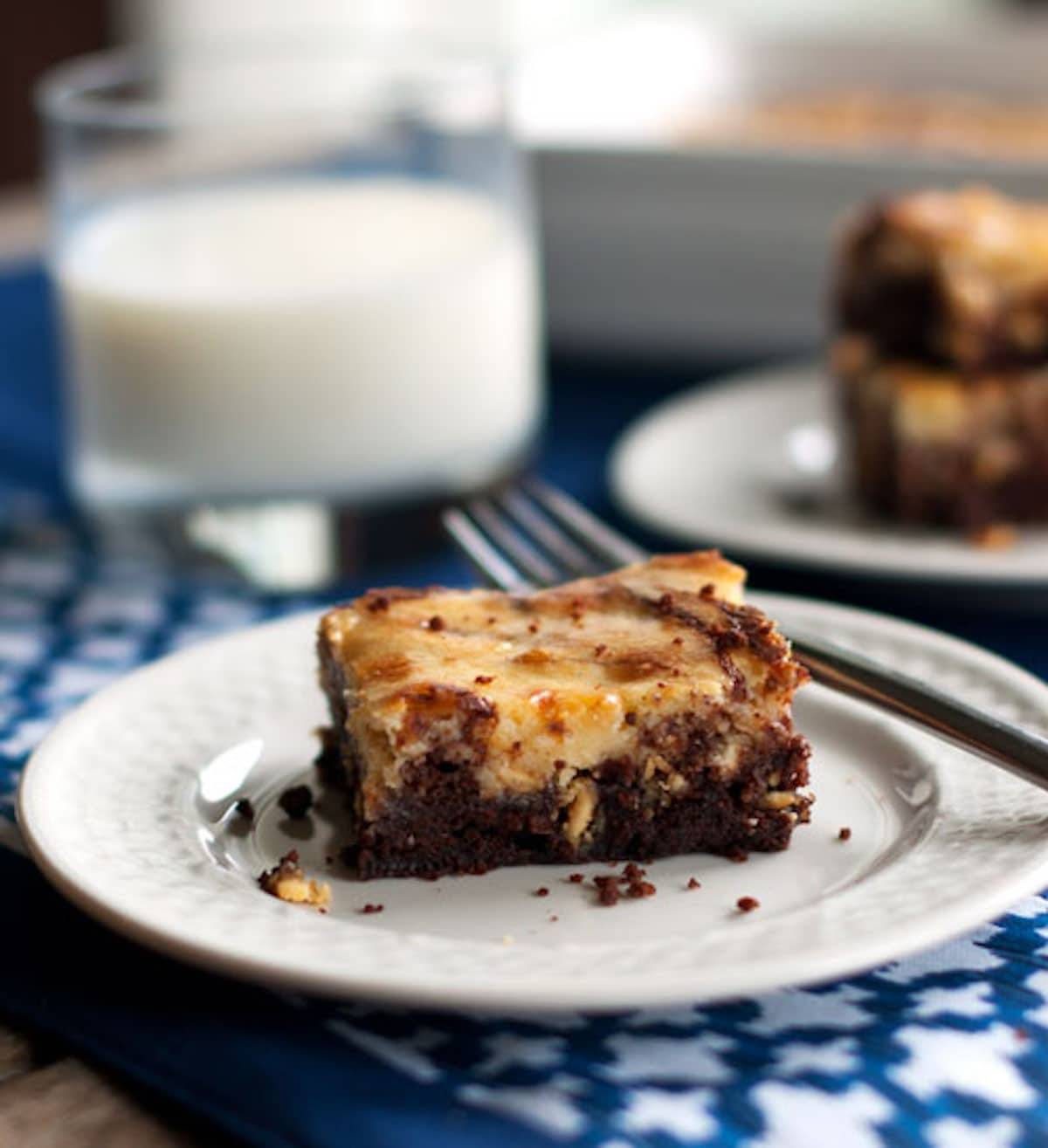 One white chocolate cheesecake brownie on a plate.
